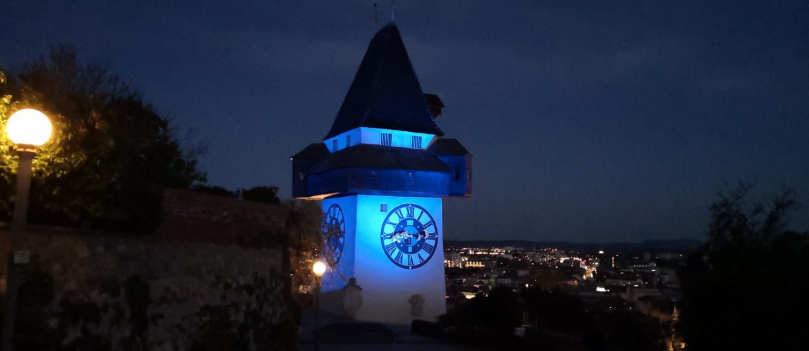 Uhrturm gelb blau beleuchtet