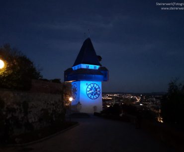 Uhrturm gelb blau beleuchtet